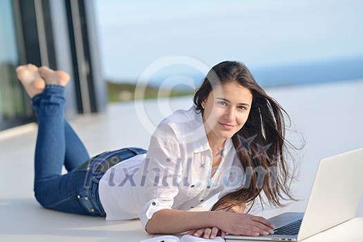 beautiful young woman relax and work on laptop computer while listening music on heaphones and read book at home beautiful young woman relax and work on laptop computer while listening music on heaphones and read book at home