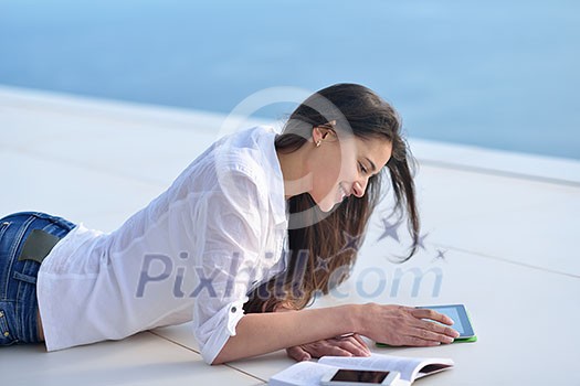 beautiful young woman relax and work on laptop computer while listening music on heaphones and read book at home beautiful young woman relax and work on laptop computer while listening music on heaphones and read book at home