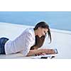 beautiful young woman relax and work on laptop computer while listening music on heaphones and read book at home