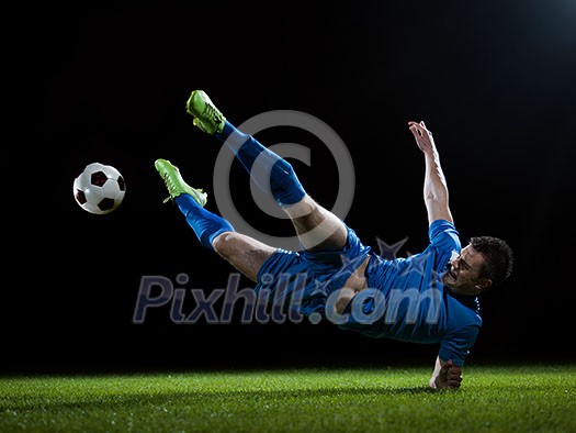 soccer player doing kick with ball on football stadium field isolated on black background soccer player doing kick with ball on football stadium field isolated on black background