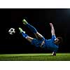 soccer player doing kick with ball on football stadium  field  isolated on black background