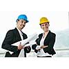 young arhitect group in big bright modern new apartment looking blueprints and building plans