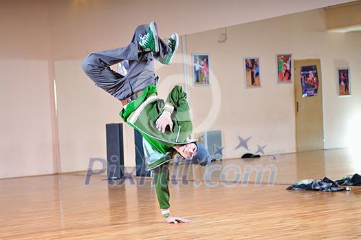 young man performing break dance in dance studio young man performing break dance in dance studio