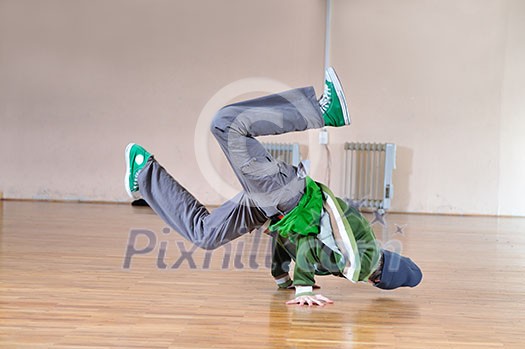 young man performing break dance in dance studio young man performing break dance in dance studio