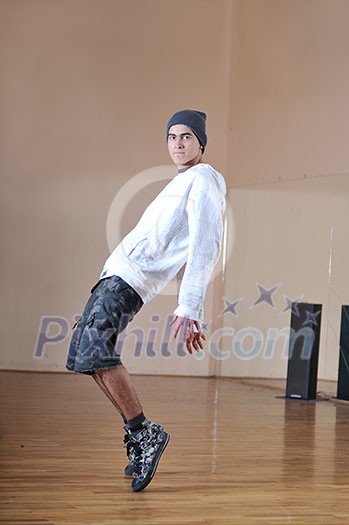 young man performing break dance in dance studio young man performing break dance in dance studio