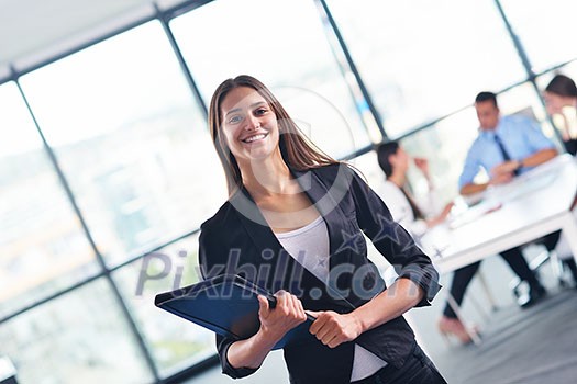 happy young business woman with her staff, people group in background at modern bright office indoors happy young business woman with her staff, people group in background at modern bright office indoors