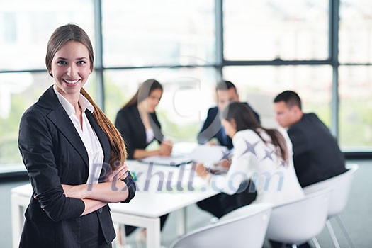 happy young business woman with her staff, people group in background at modern bright office indoors happy young business woman with her staff, people group in background at modern bright office indoors