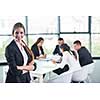 happy young business woman  with her staff,  people group in background at modern bright office indoors