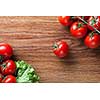 red tomatoes with green salad on wood