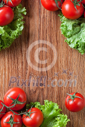 red tomatoes with green salad on wood red tomatoes with green salad on wood