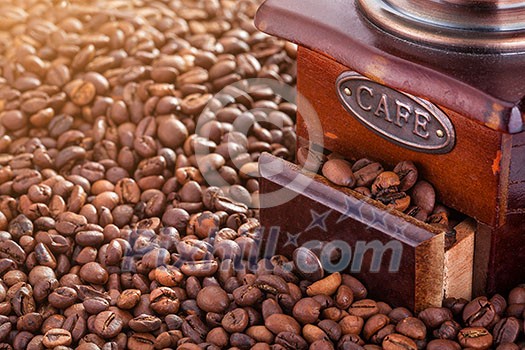 Retro manual coffee mill on roasted coffee beans Retro manual coffee mill on roasted coffee beans