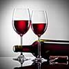 Wine in glasses and bottle on white
