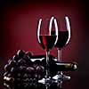 Wine in glasses with grape and bottle on red