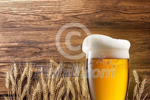 Glass of beer with wheat on wooden background Glass of beer with wheat on wooden background