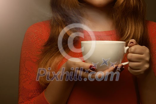 woman holding hot cup and smiles woman holding hot cup and smiles