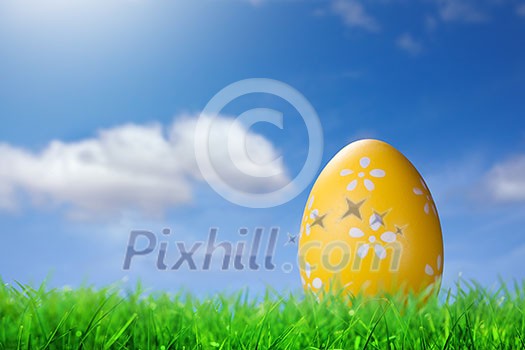 Color easter egg in the grass against blue sky Color easter egg in the grass against blue sky