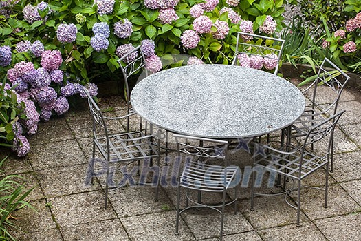 table and chairs in garden with color hydrangea flowers table and chairs in garden with color hydrangea flowers