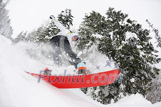 Snowboarder doing a jump and free ride on powder snow at winter season Snowboarder doing a jump and free ride on powder snow at winter season