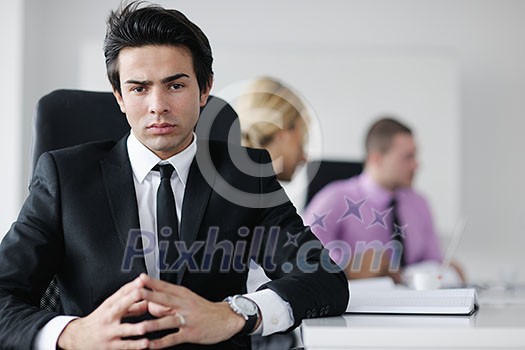 Confident young business man attending a meeting with his colleagues Confident young business man attending a meeting with his colleagues