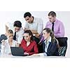 Group of young business people sitting in board room during meeting and discussing with paperwork
