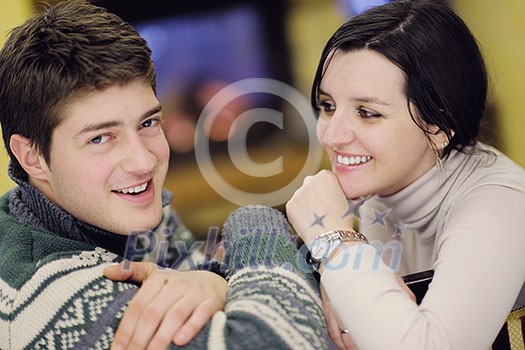 happy Young romantic couple and relaxing sofa in front of fireplace at winter season in home happy Young romantic couple and relaxing sofa in front of fireplace at winter season in home