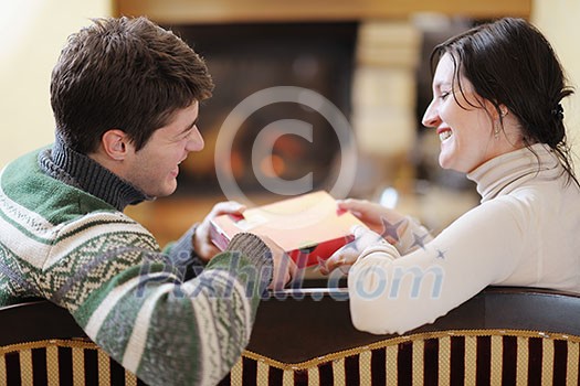 happy Young romantic couple and relaxing sofa in front of fireplace at winter season in home happy Young romantic couple and relaxing sofa in front of fireplace at winter season in home