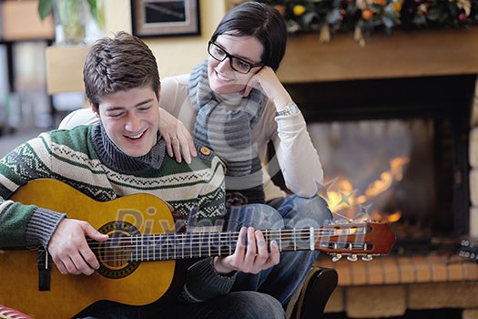 happy Young romantic couple and relaxing sofa in front of fireplace at winter season in home happy Young romantic couple and relaxing sofa in front of fireplace at winter season in home