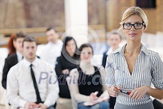 business woman standing with her staff in background at modern bright office conference room business woman standing with her staff in background at modern bright office conference room