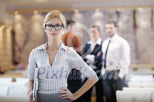 business woman standing with her staff in background at modern bright office conference room business woman standing with her staff in background at modern bright office conference room