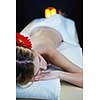 Beautiful young woman in spaand wellness. Face back and  stone massage