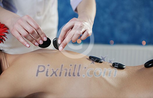 Beautiful young woman in spaand wellness. Face back and stone massage Beautiful young woman in spaand wellness. Face back and stone massage