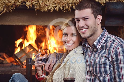 happy Young romantic couple and relaxing sofa in front of fireplace at winter season in home happy Young romantic couple and relaxing sofa in front of fireplace at winter season in home