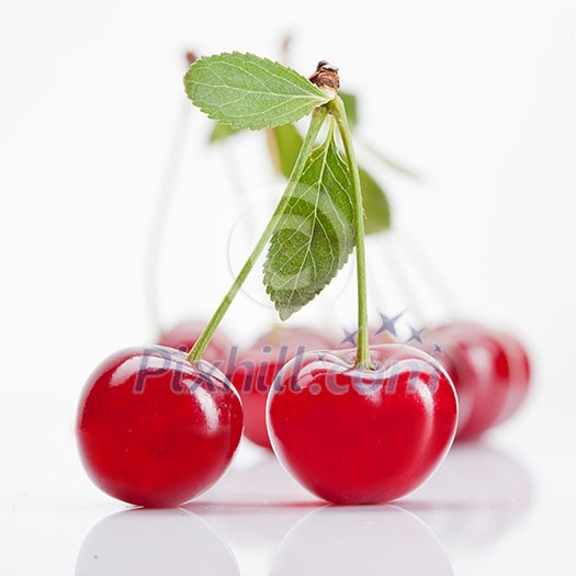 Red cherry with leaves isolated on white Red cherry with leaves isolated on white