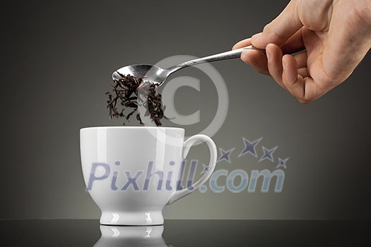 tea pour out into white cup on grey tea pour out into white cup on grey