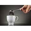 tea pour out into white cup on grey