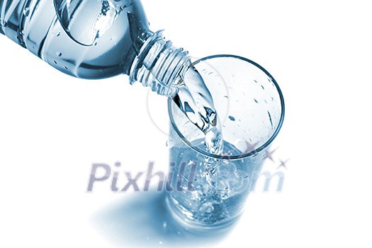 water pouring into glass from bottle isolated on white water pouring into glass from bottle isolated on white
