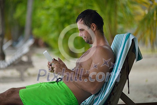business man relaxing and use tablet computer at beautiful tropical beach business man relaxing and use tablet computer at beautiful tropical beach