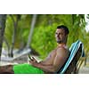 business man relaxing and use tablet computer at beautiful tropical beach