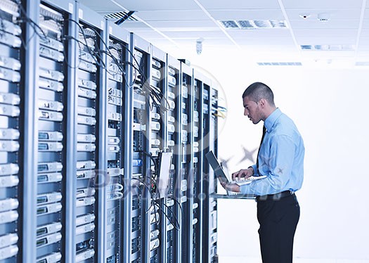 young engeneer business man with thin modern aluminium laptop in network server room young engeneer business man with thin modern aluminium laptop in network server room