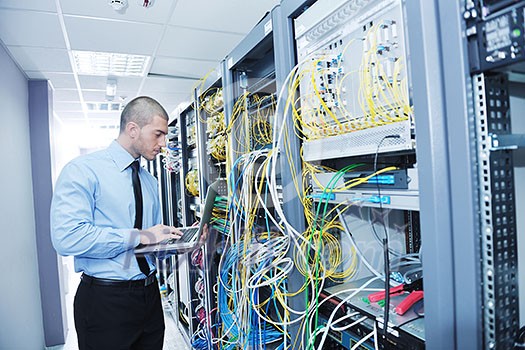 young engeneer business man with thin modern aluminium laptop in network server room young engeneer business man with thin modern aluminium laptop in network server room