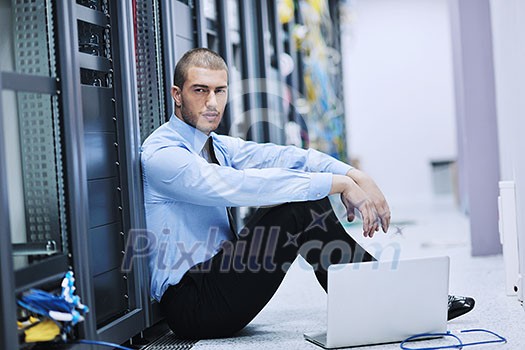 young engeneer business man with thin modern aluminium laptop in network server room young engeneer business man with thin modern aluminium laptop in network server room
