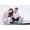 joyful couple relax and work on laptop computer at modern living room indoor home