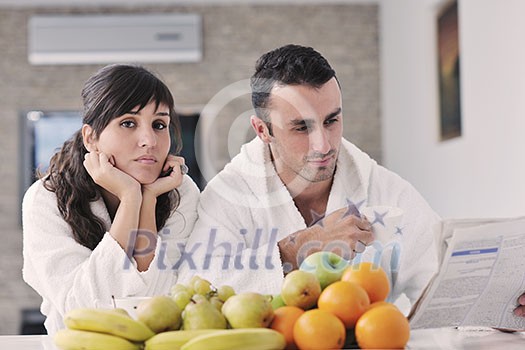 young family couple read newspaper at kitchen in morning with fresh breakfast fruits food and coffee drink on table young family couple read newspaper at kitchen in morning with fresh breakfast fruits food and coffee drink on table