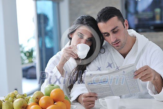 young family couple read newspaper at kitchen in morning with fresh breakfast fruits food and coffee drink on table young family couple read newspaper at kitchen in morning with fresh breakfast fruits food and coffee drink on table