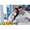 young family couple read newspaper at kitchen in morning with  fresh breakfast  fruits food and coffee drink on table