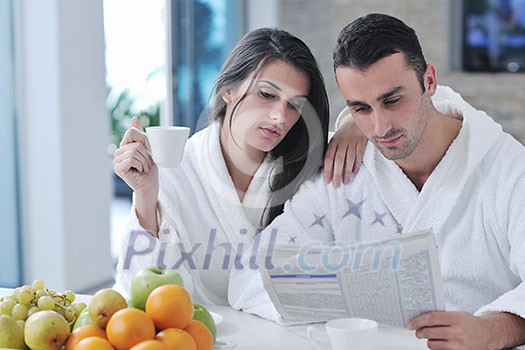 young family couple read newspaper at kitchen in morning with fresh breakfast fruits food and coffee drink on table young family couple read newspaper at kitchen in morning with fresh breakfast fruits food and coffee drink on table
