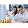 young family couple read newspaper at kitchen in morning with  fresh breakfast  fruits food and coffee drink on table