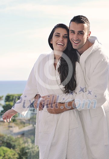 happy young couple relax on balcony outdoor with ocean and blue sky in background happy young couple relax on balcony outdoor with ocean and blue sky in background