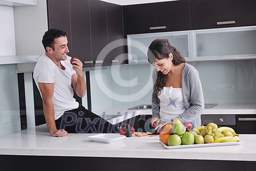 happy young couple have fun in modern kitchen indoor while preparing fresh fruits and vegetables food salad happy young couple have fun in modern kitchen indoor while preparing fresh fruits and vegetables food salad