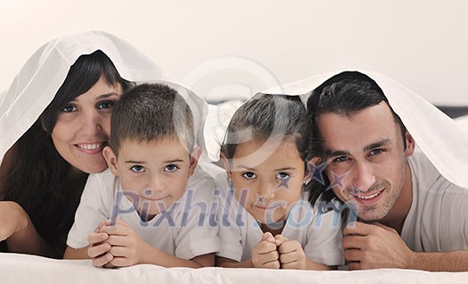 happy young Family in their bedroom have fun and play in bed happy young Family in their bedroom have fun and play in bed